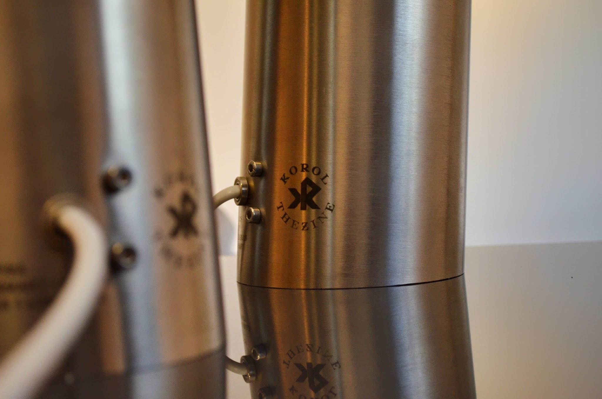 A pair of brushed stainless steel luminaires standing side by side